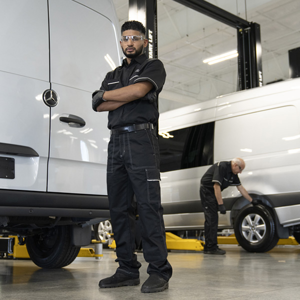 Service technician posing in front of a van.