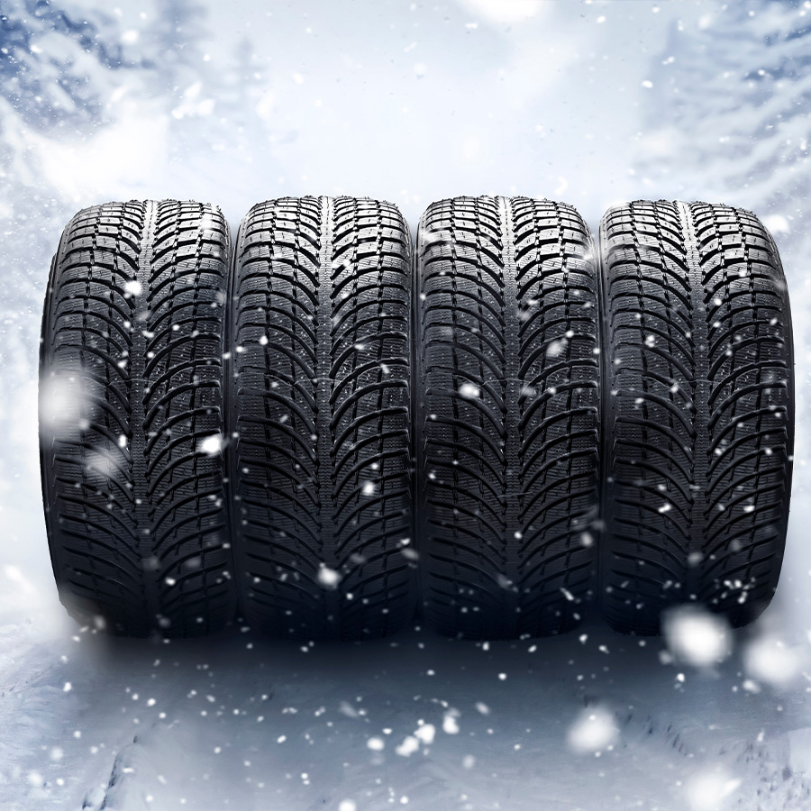 Four winter tires on a snowy background.