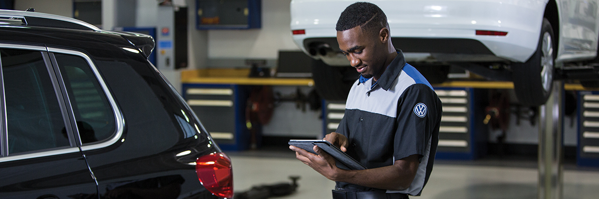 Mechanic with tablet in a car workshop.