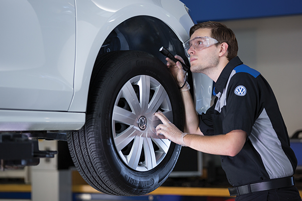 VW Service technician inspecting car