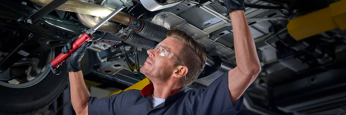 Mechanic checking out under carriage of a Cadillac