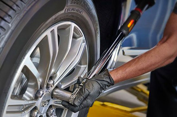 Cadillac mechanic servicing tires