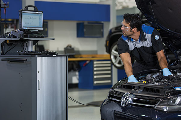 VW Mechanic inspecting car engine