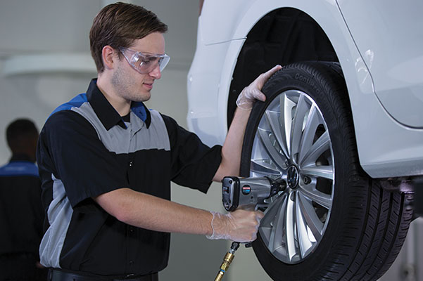 Mechanic tightening the bolts on a car tire