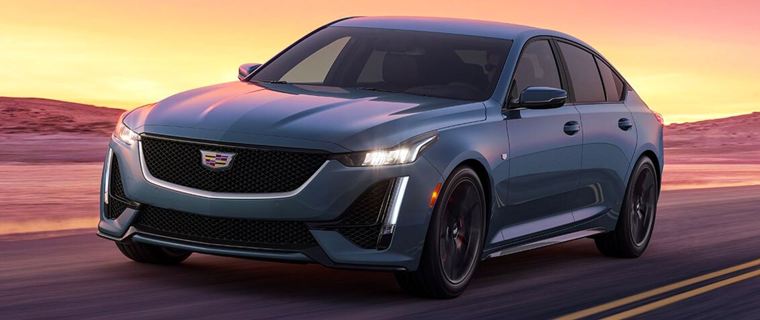 2024 Cadillac CT5 driving down the road at sunset