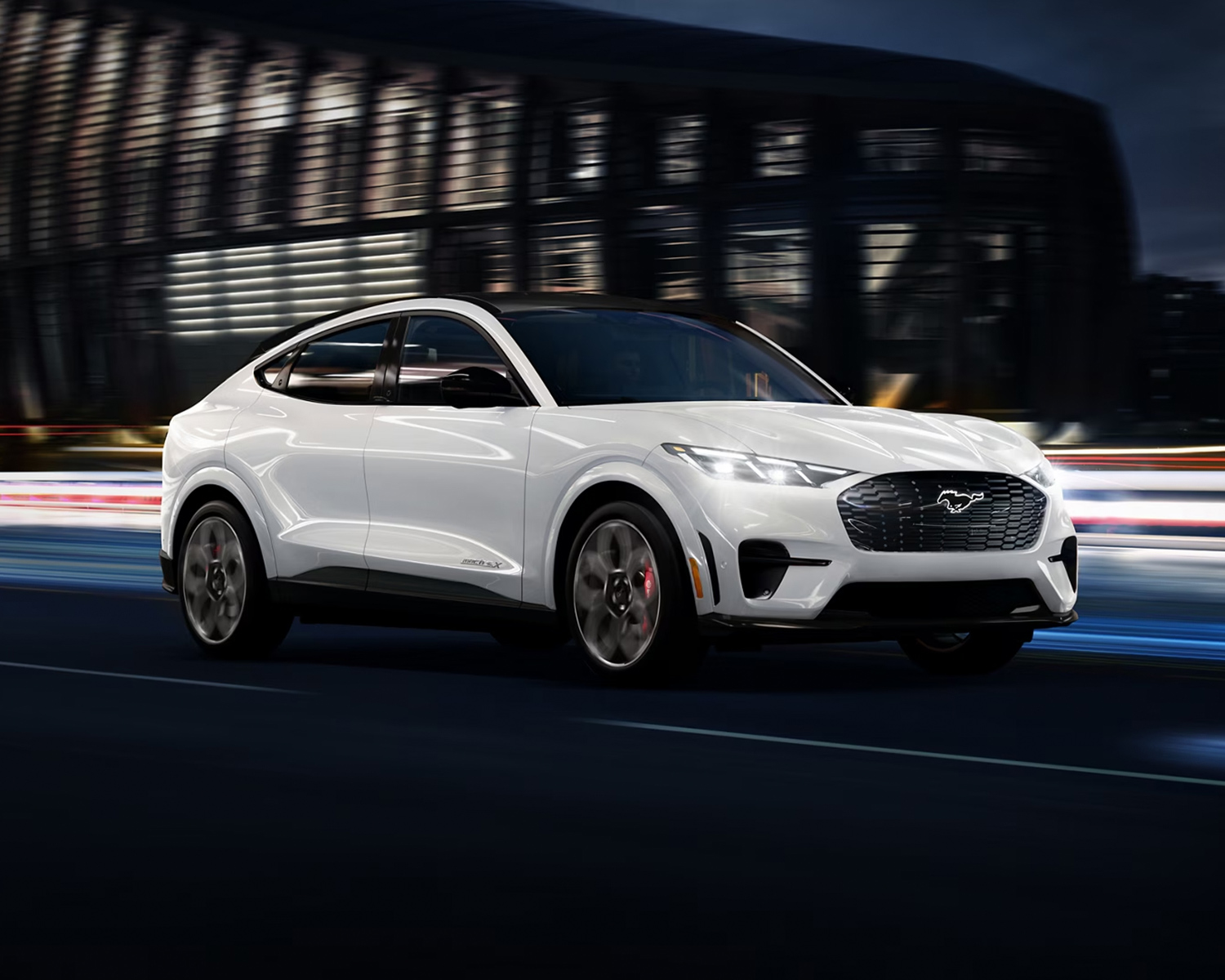 2025 Ford Mustang Mach-E driving down a highway at night