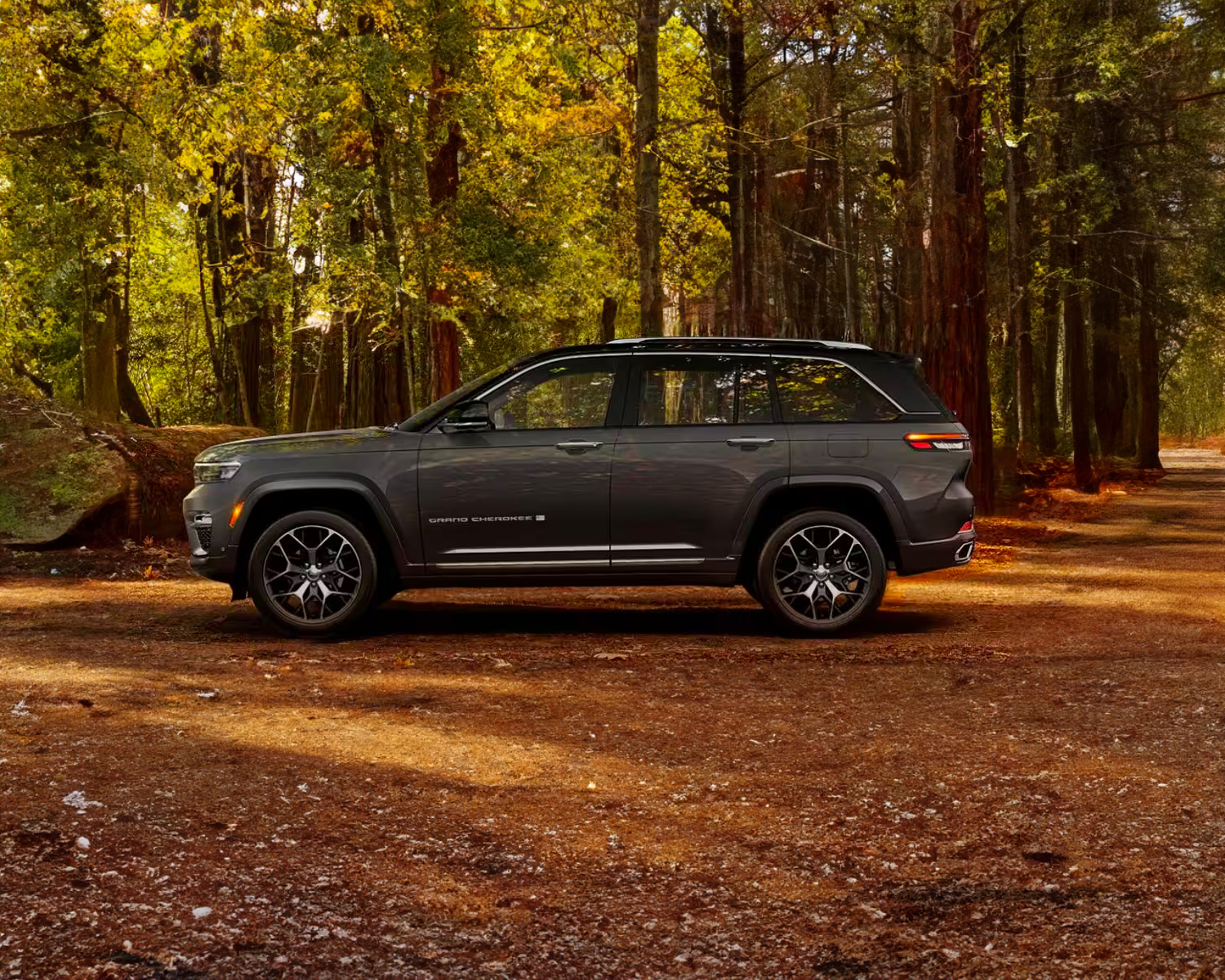 side view of a 2024 Jeep Grand Cherokee in the woods