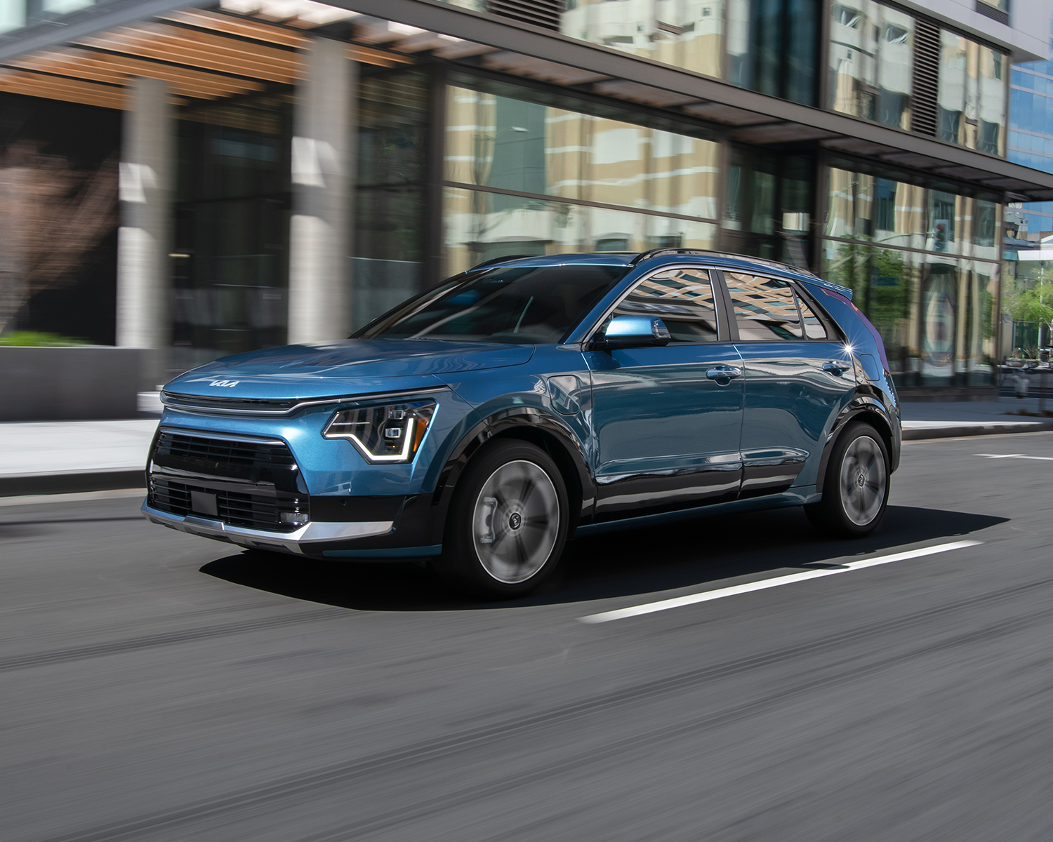 2024 Kia Niro Plug-in Hybrid driving through a city street