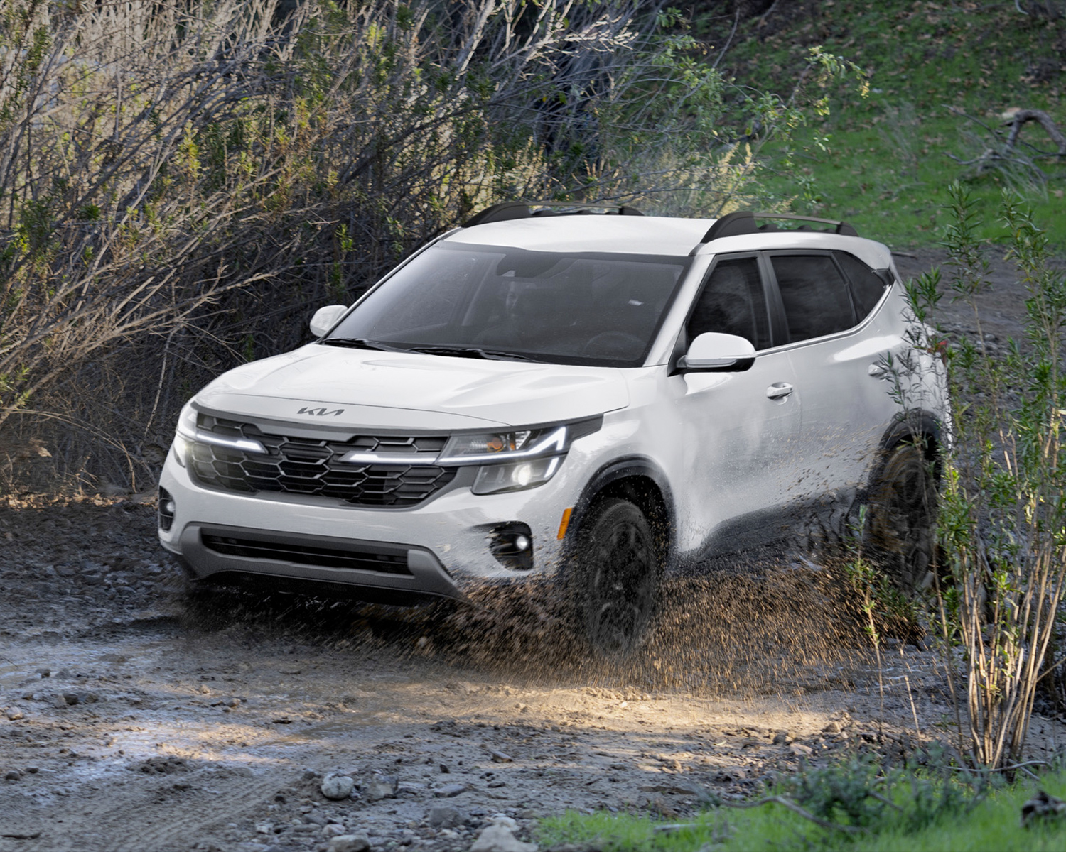 2025 Kia Seltos driving through a muddy pathway