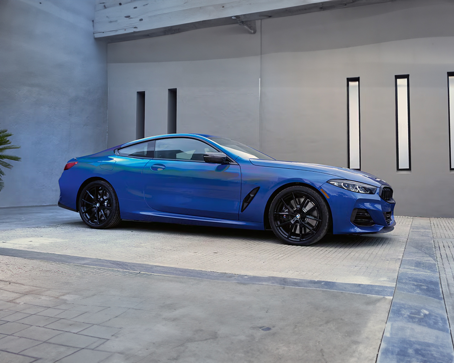 Side profile shot of the 2025 BMW 8-Series parked in front of building