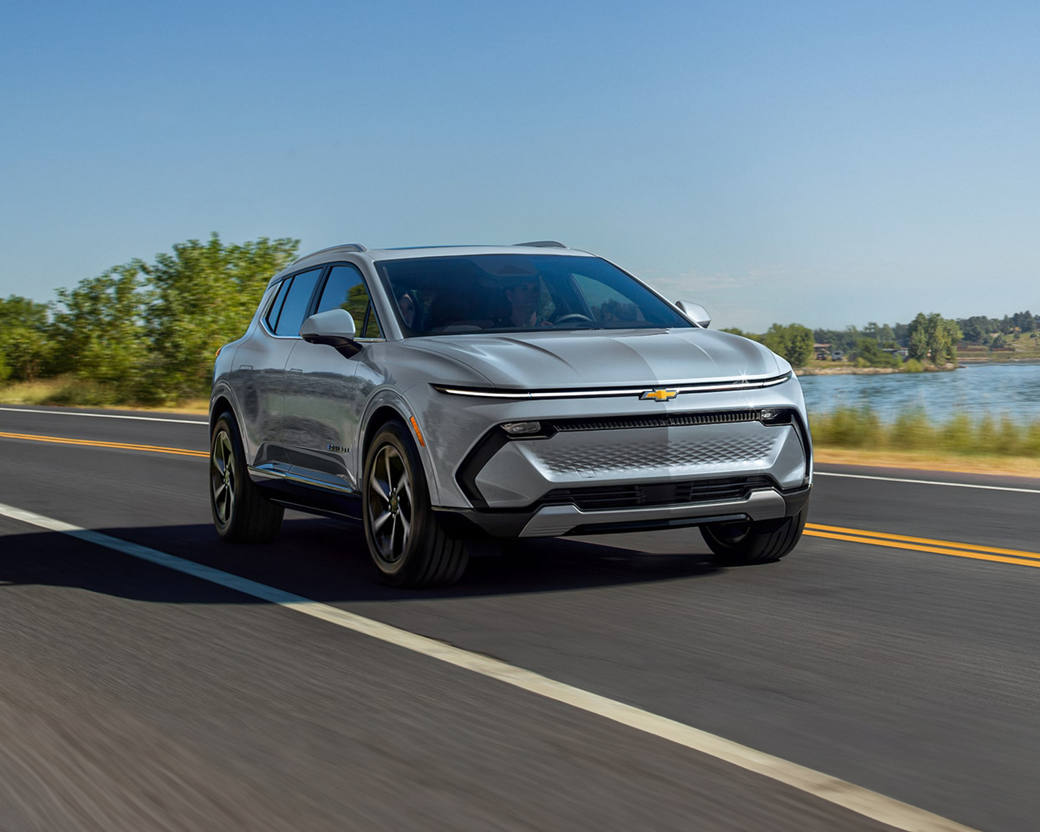 2025 Equinox EV driving down a scenic road