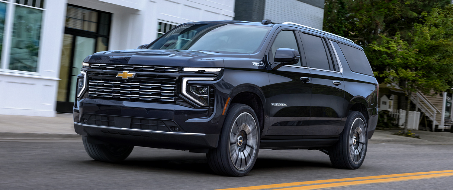 Chevrolet Suburban driving down a town street