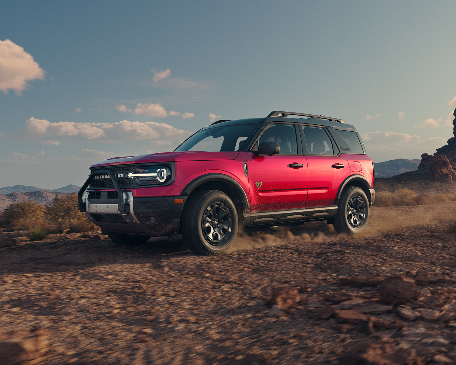 Red 2025 Ford Bronco Sport driving on dirt road