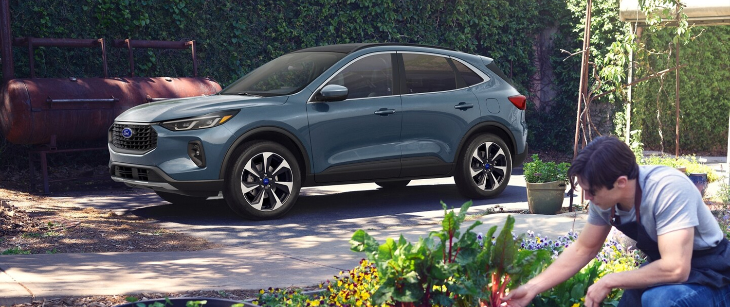 2025 Ford Escape parked outside a home with someone gardening