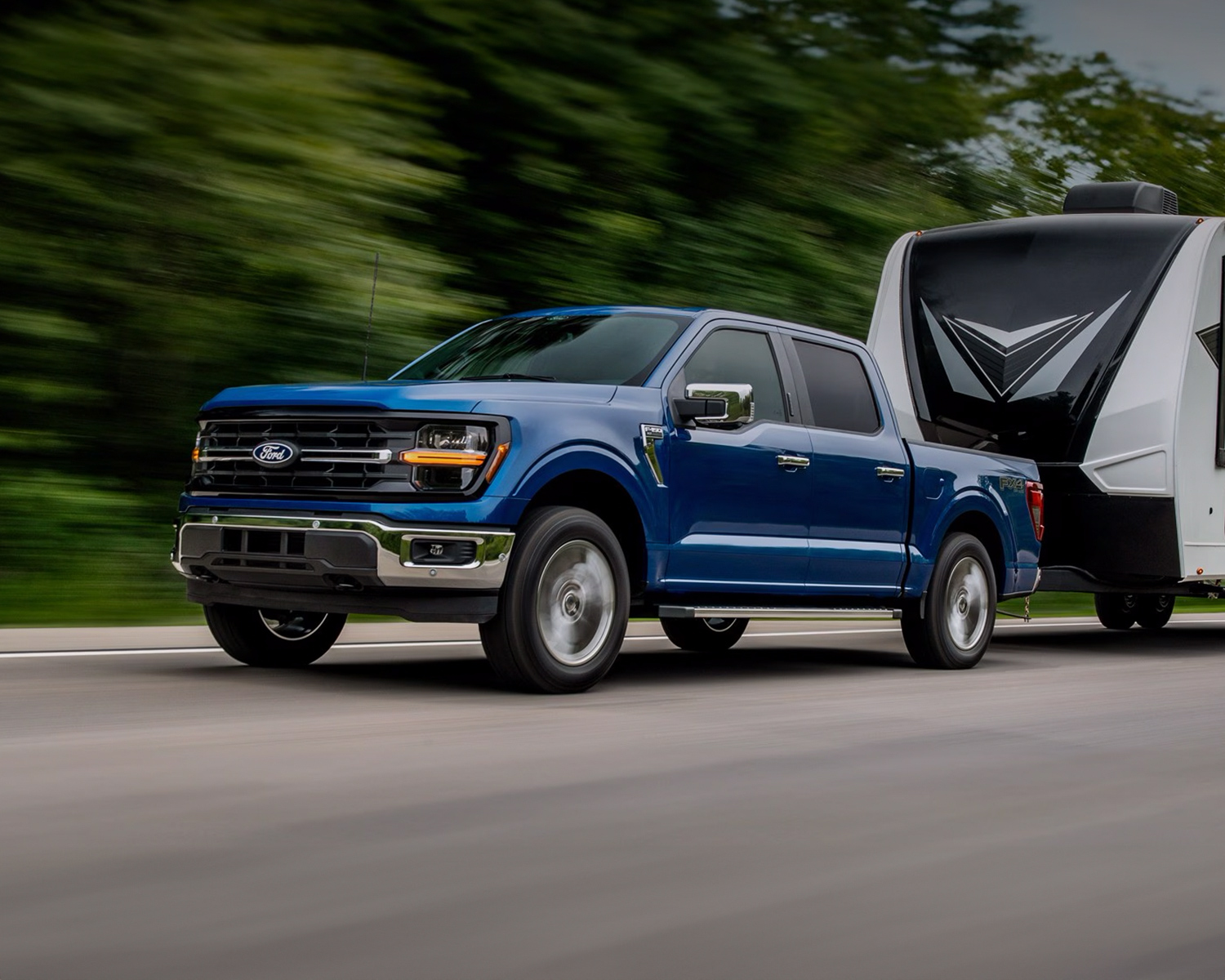 Blue 2025 Ford F-150 towing motor home.