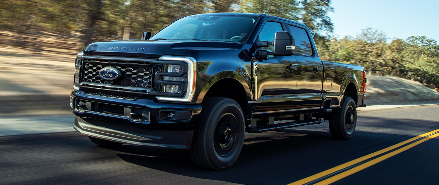 2025 Ford Super Duty® STX® Package pickup in Agate Black Metallic being driven on a paved road