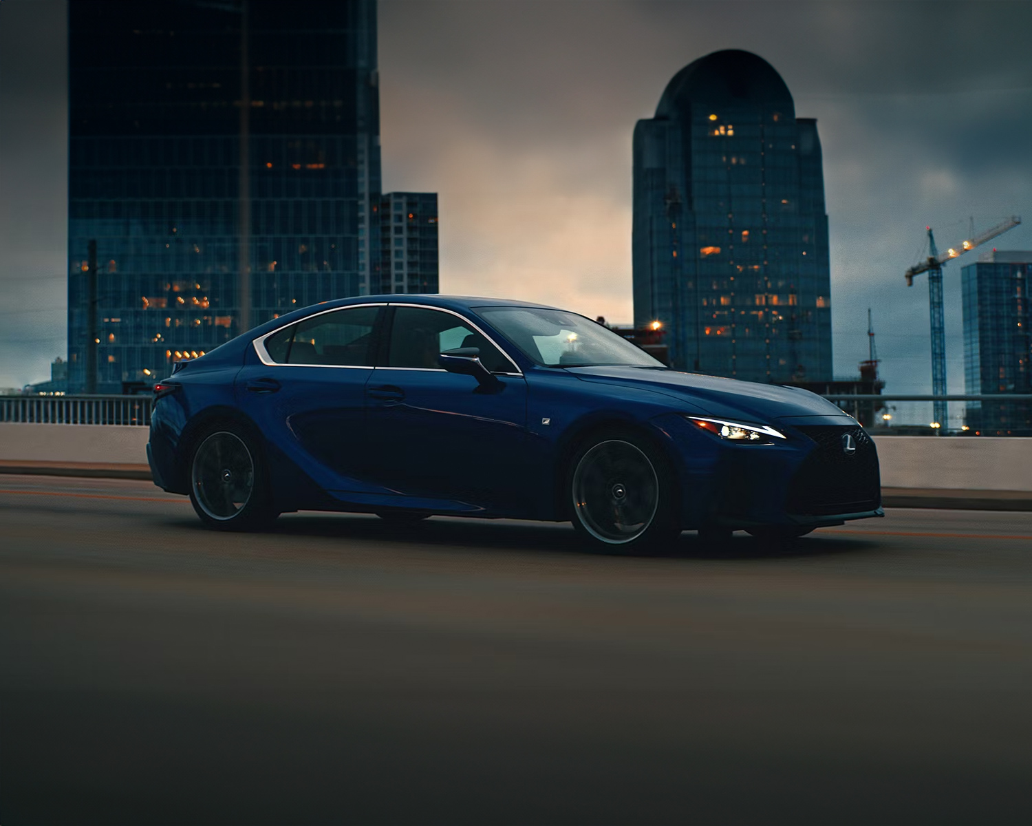 2025 Lexus IS driving through the city at night