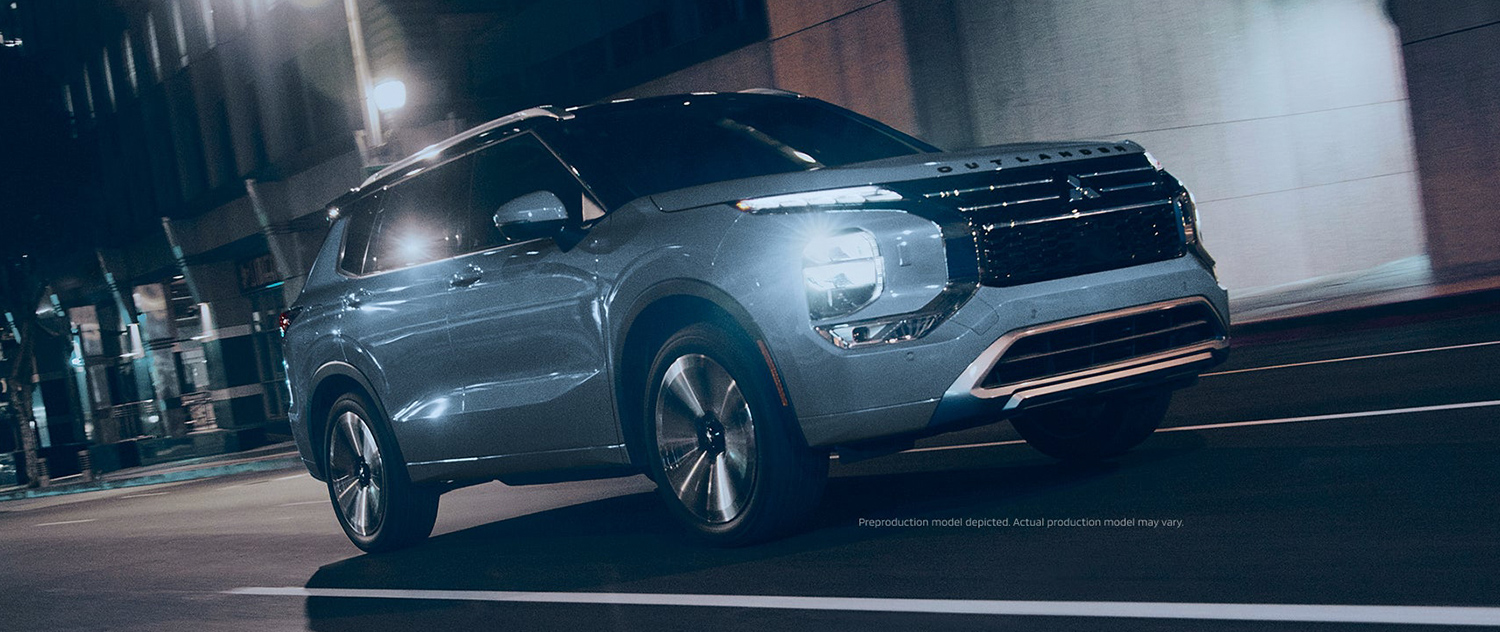 3/4 view of a 2025 Mitsubishi Outlander driving down a city street