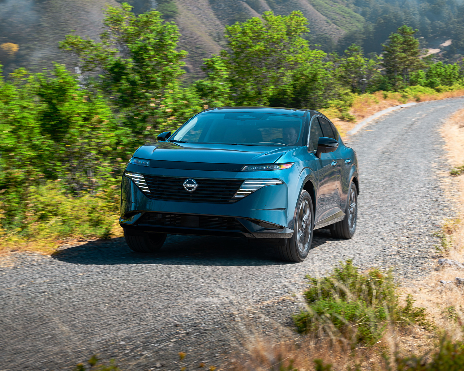 2025 Nissan Murano driving down a gravel road through the mountains