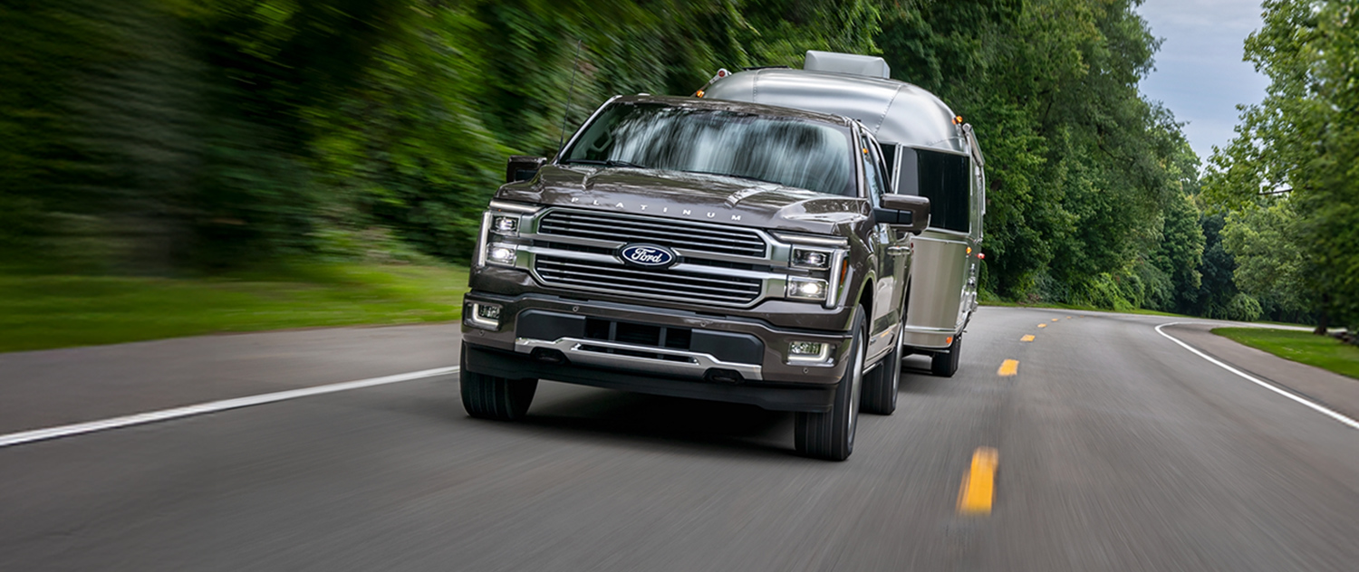 2026 Ford F-150® Platinum® truck in Marsh Gray pulling a camper