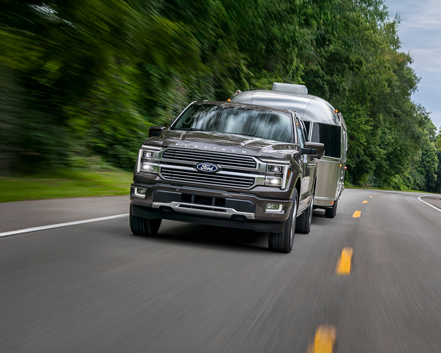 Ford F-150 driving down a road while towing a trailer