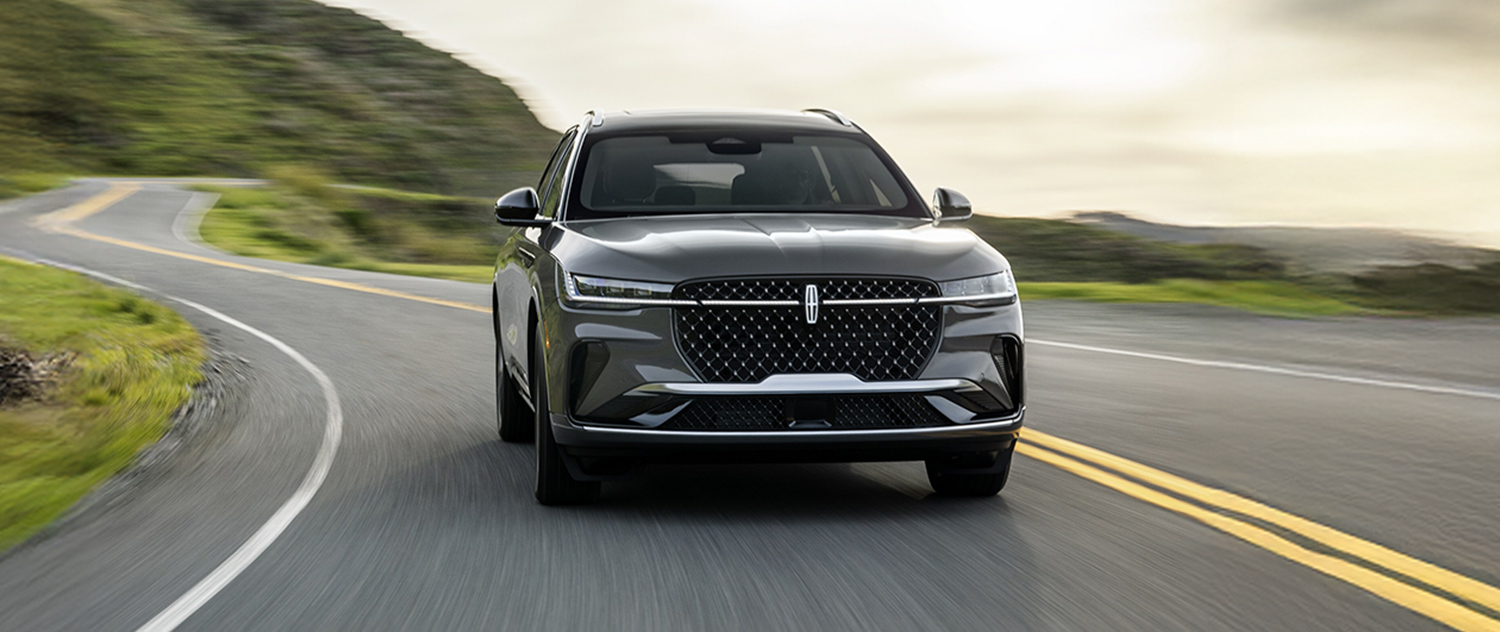 2026 Lincoln Nautilus driving down the road with trees in the background
