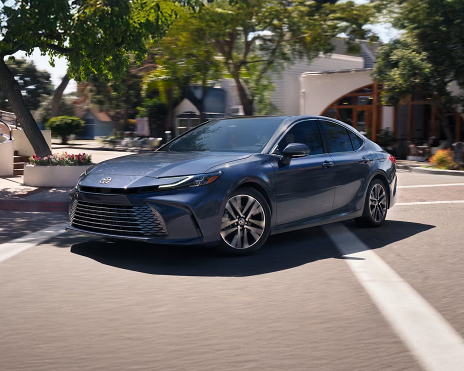 Camry driving down a town street