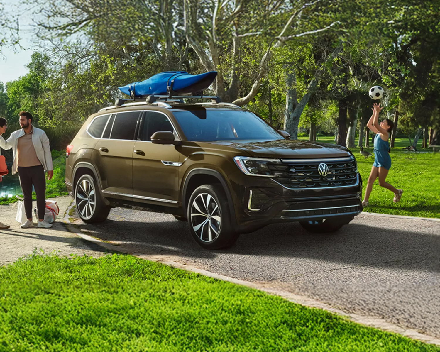 VW Atlas parked outside on a nice day with a family shown