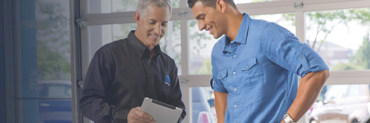 A mopar technician and client looking at a tablet device