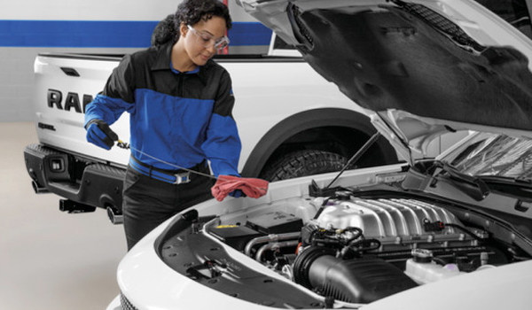 View of a service professional checking engine oil.