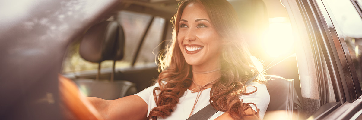 Happy woman driving in car