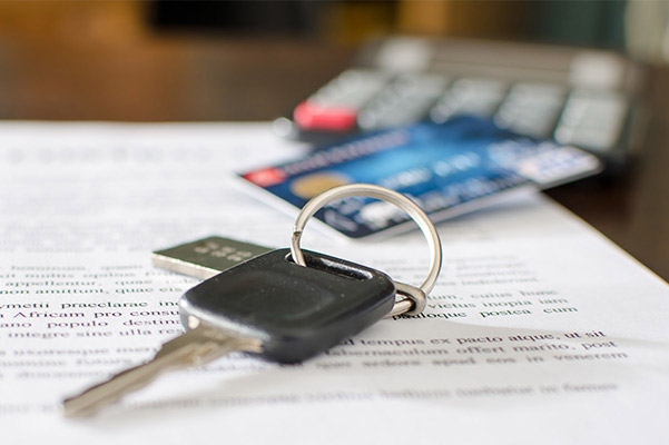 close up of car keys, calculator, and credit card