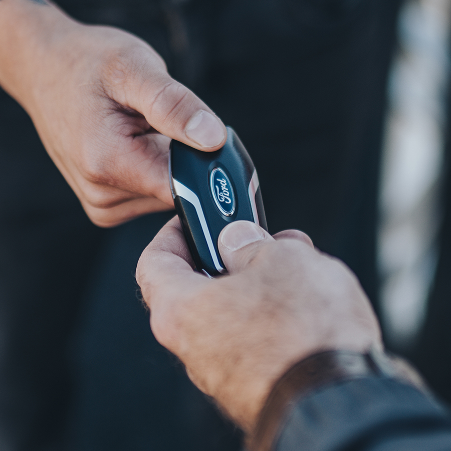 customer handing Ford key to dealer