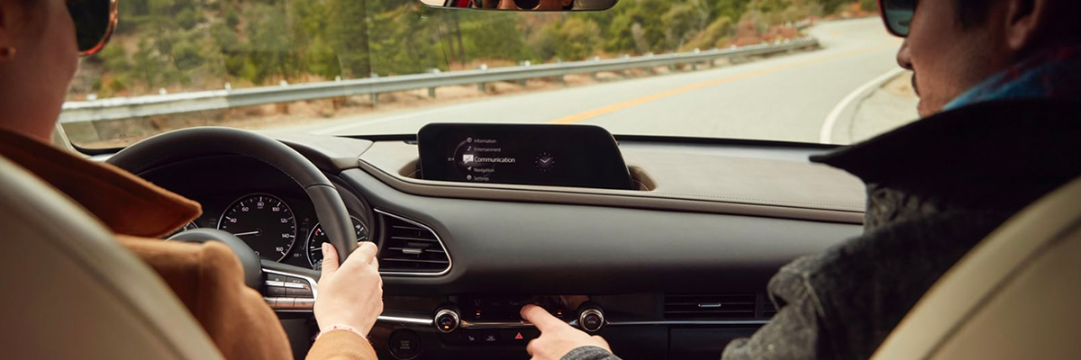 Couple driving on scenic road in modern car