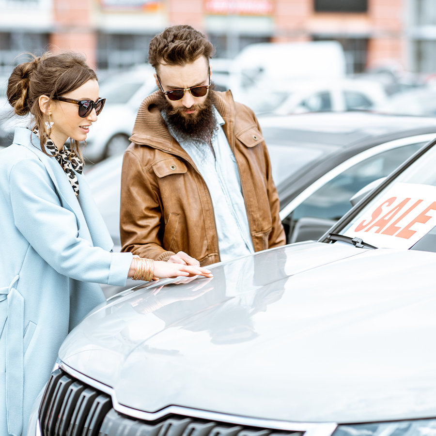 people looking in lot at car