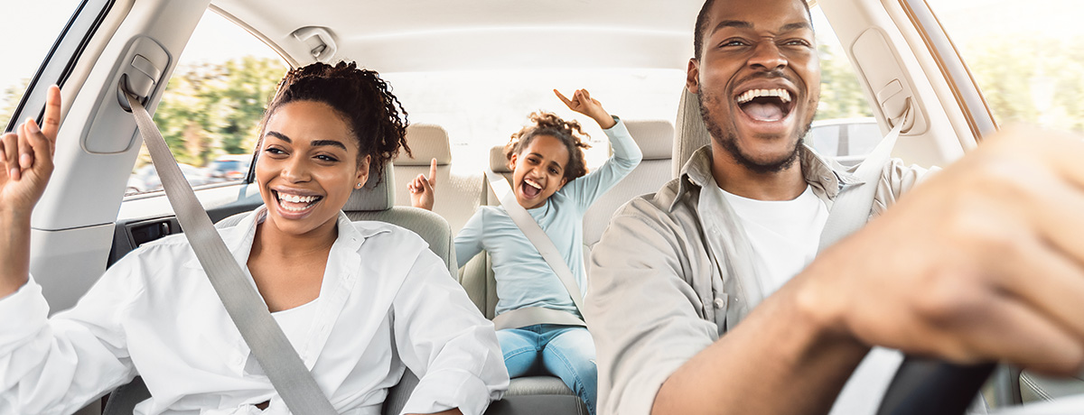 Family smiling and driving in their car