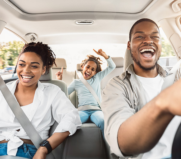 Family smiling in car driving