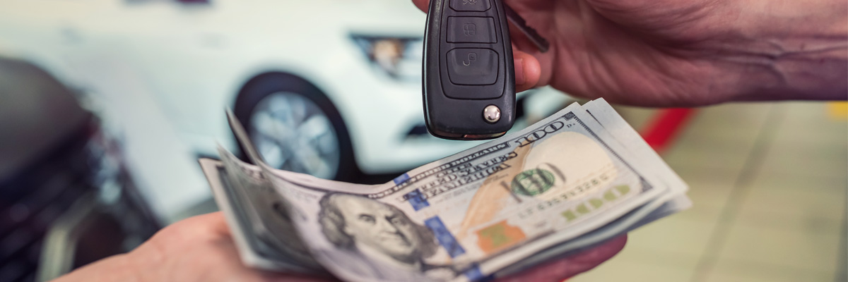 Close up of a car key being handed from one person to another