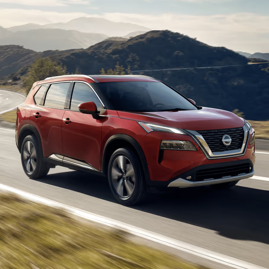 Red Nissan Rogue on the road