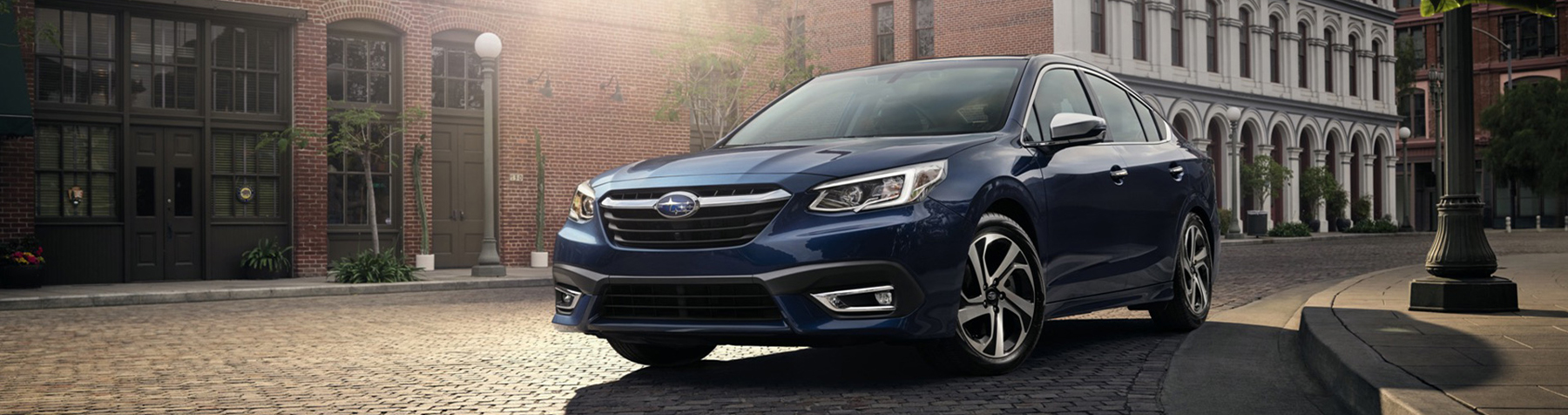 Blue Subaru Legacy sedan parked on a city street
