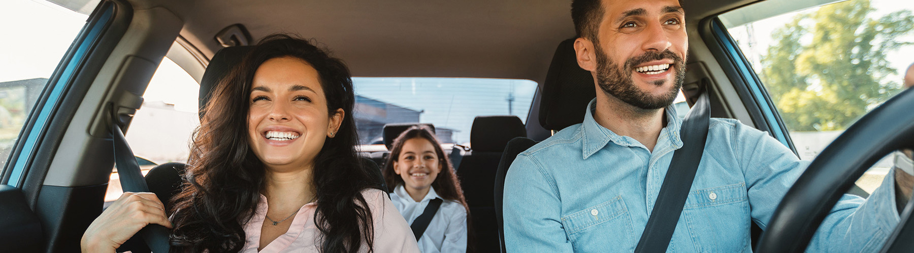 happy fmaily driving in new car