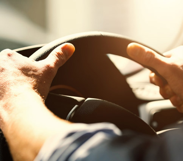 close up of hands on a steering wheel